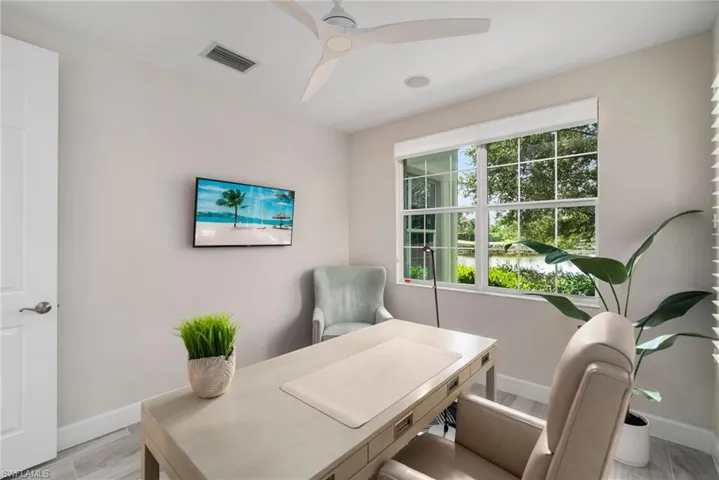 Office space with light wood-type flooring and ceiling fan