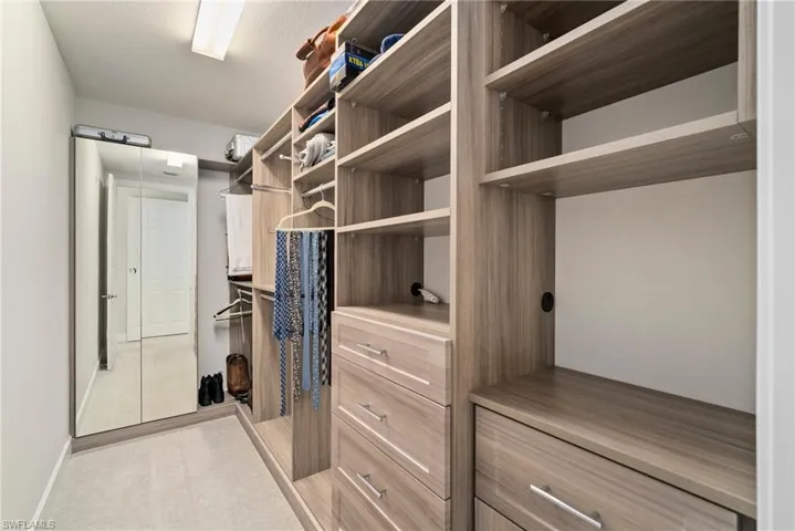 Spacious closet with light colored carpet