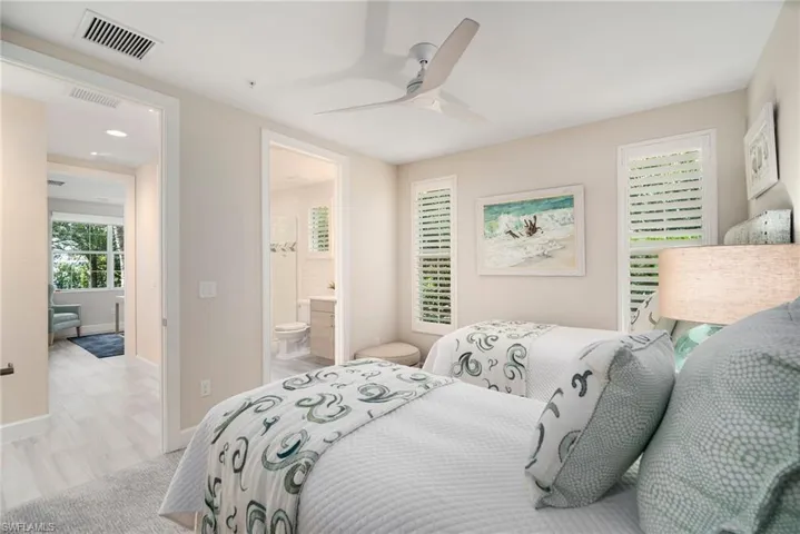 Bedroom featuring ceiling fan, connected bathroom, and light hardwood / wood-style floors