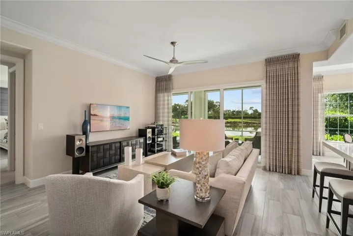 Living room featuring light hardwood / wood-style flooring, ceiling fan, and ornamental molding