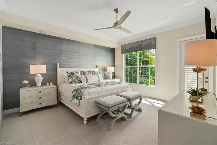 Carpeted bedroom featuring multiple windows, ceiling fan, and crown molding