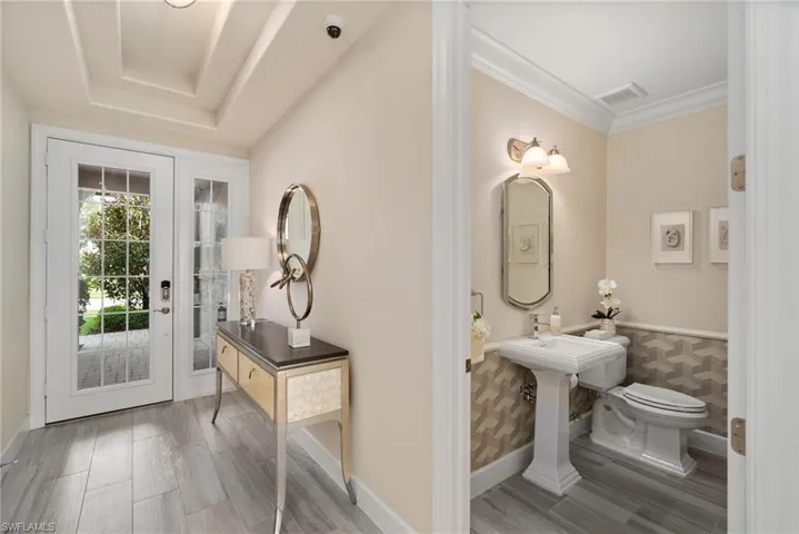 Bathroom with hardwood / wood-style floors, toilet, and a tray ceiling