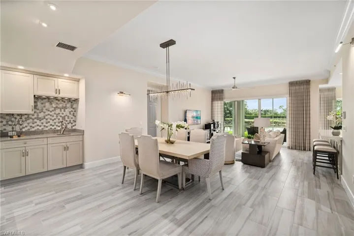 Dining room featuring crown molding and ceiling fan with notable chandelier