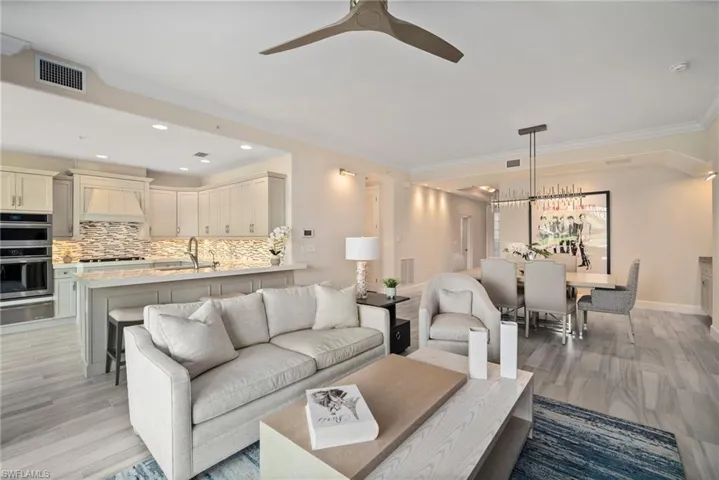 Living room with crown molding, sink, and ceiling fan