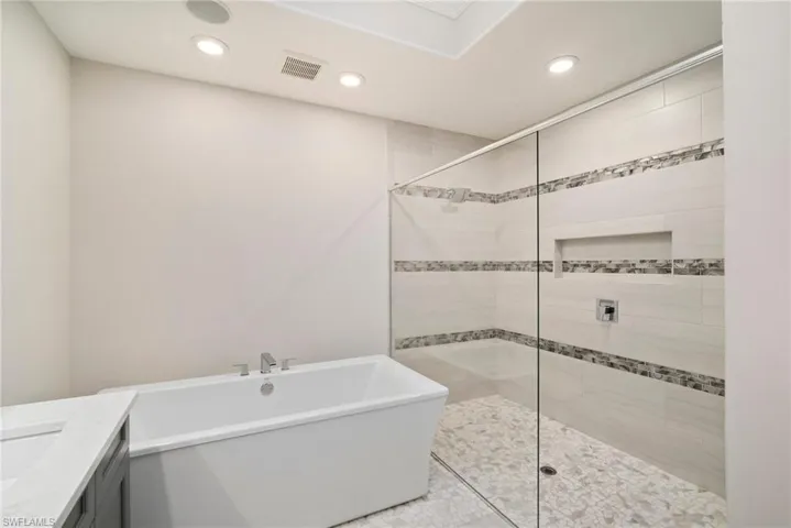 Bathroom featuring independent shower and bath and vanity