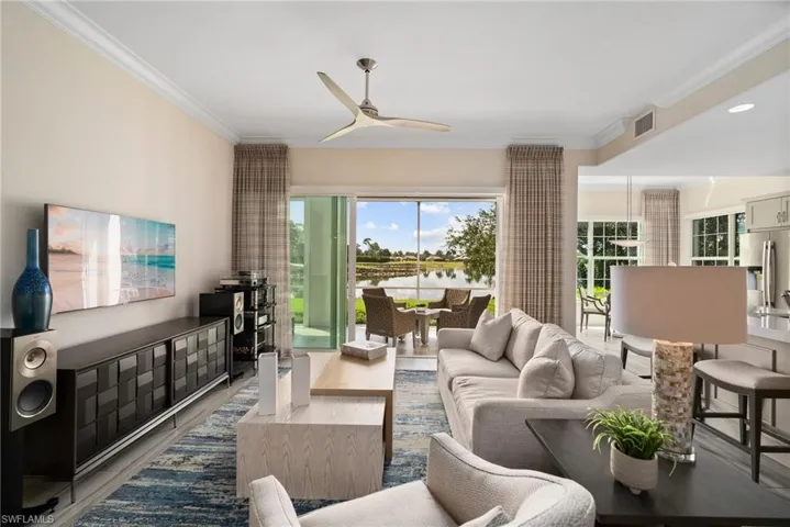 Living room with hardwood / wood-style flooring, ornamental molding, and ceiling fan