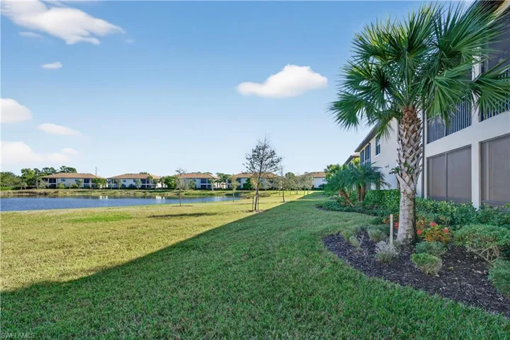 View of grassy yard featuring a water view and a residential view