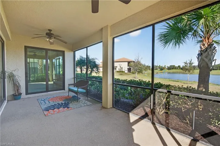 Unfurnished sunroom featuring ceiling fan and a water view