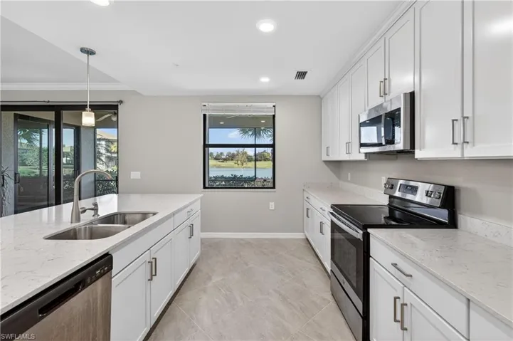 Kitchen with appliances with stainless steel finishes, pendant lighting, white cabinetry, light stone countertops, and recessed lighting