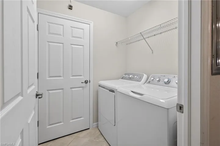 Laundry area with light tile patterned floors and independent washer and dryer