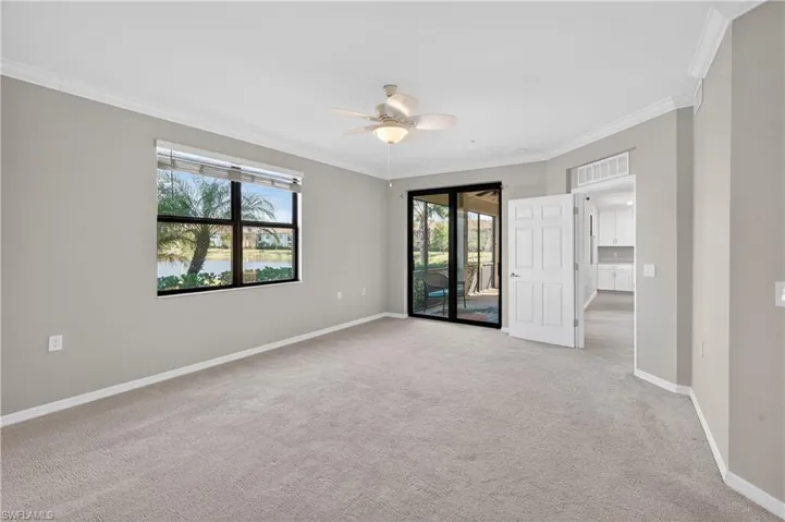 Spare room with crown molding, light carpet, a water view, and ceiling fan