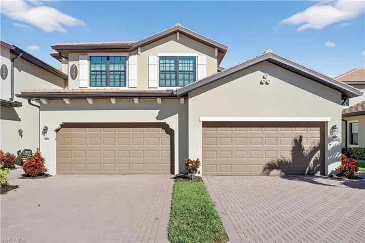 View of front of property featuring stucco siding, decorative driveway, and a tile roof