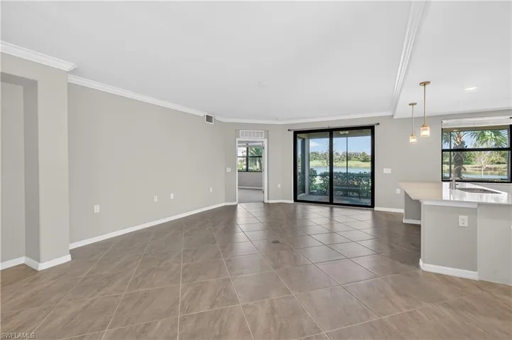 Unfurnished living room with crown molding and light tile patterned floors