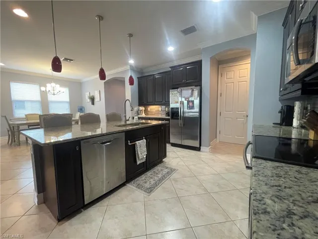 Kitchen with decorative light fixtures, tasteful backsplash.