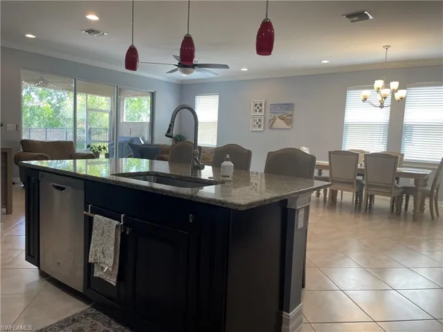 Kitchen with stainless steel dishwasher, an island with sink.
