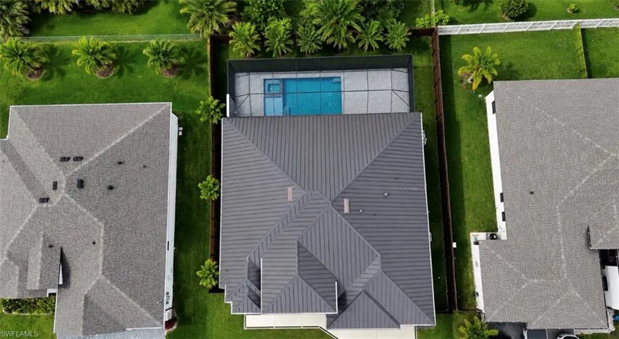 Modern residential property featuring a gray metal roof, private swimming pool, and screened enclosure