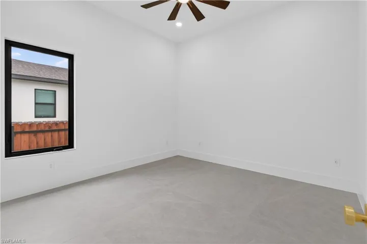 Bright interior space featuring a multi-pane window with black framing, wood-finish ceiling fan, recessed lighting, and light grey tile flooring
