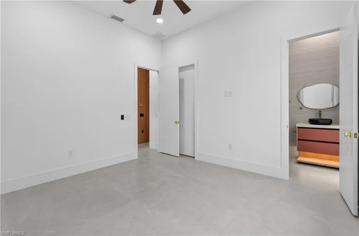 Spacious interior room with light grey tile flooring and bright white walls