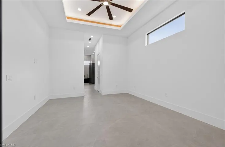 Spacious interior featuring a contemporary ceiling fan, recessed lighting, and a unique clerestory window