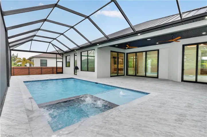 Screened lanai featuring a rectangular pool and integrated spa