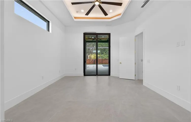 Spacious interior featuring neutral tone flooring, high baseboards, and a contemporary ceiling fan
