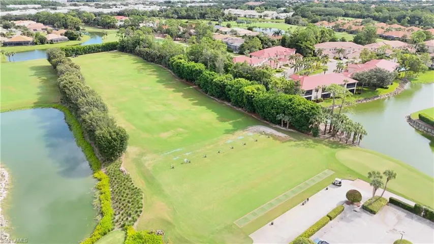Aerial perspective of suburban area featuring a nearby body of water and a golf course