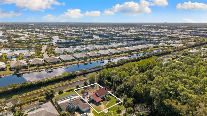 Aerial view of residential area featuring property parcel outlined and a large body of water