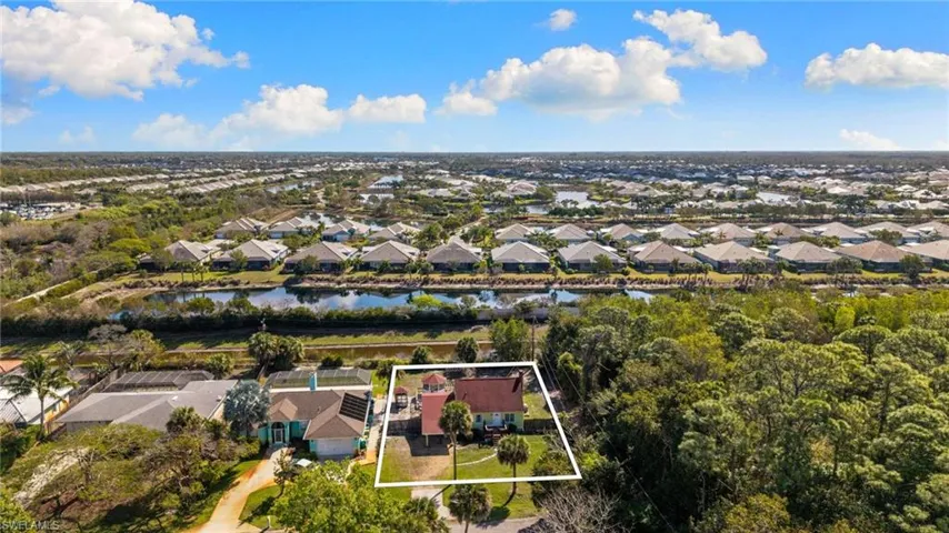 Aerial perspective of suburban area featuring a nearby body of water and property parcel outlined