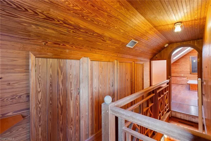 Hallway with wooden walls and a vaulted wooden ceiling