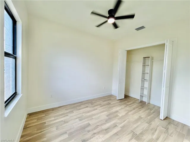 Unfurnished bedroom featuring light wood-style floors, a ceiling fan, and a closet