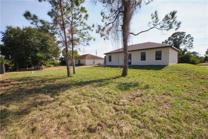 Back of property with stucco siding and a yard