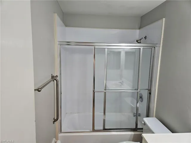 Bathroom with enclosed tub / shower combo and toilet
