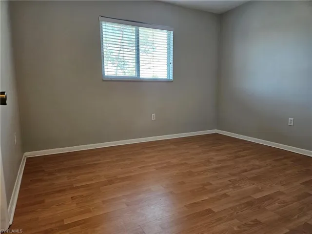 Unfurnished room with dark hardwood / wood-style floors