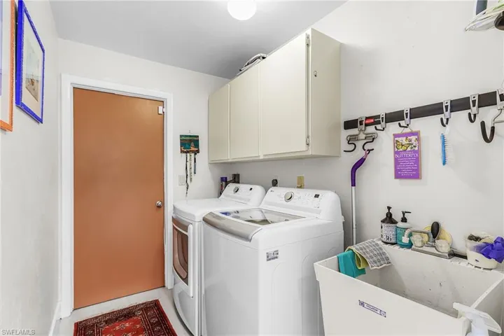 Laundry room featuring cabinet space and washer and clothes dryer