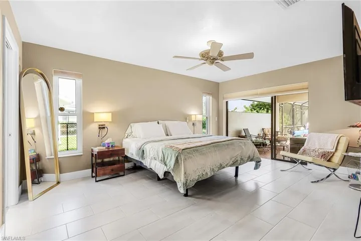 Bedroom featuring access to outside, a ceiling fan, and light tile patterned floors