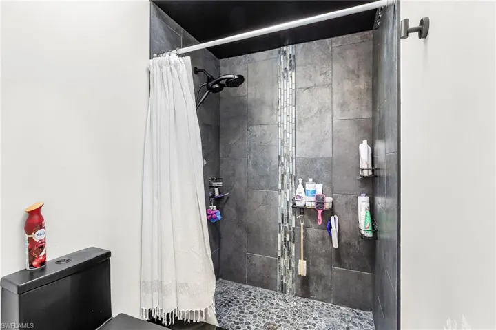 Full bathroom with toilet and a stall shower
