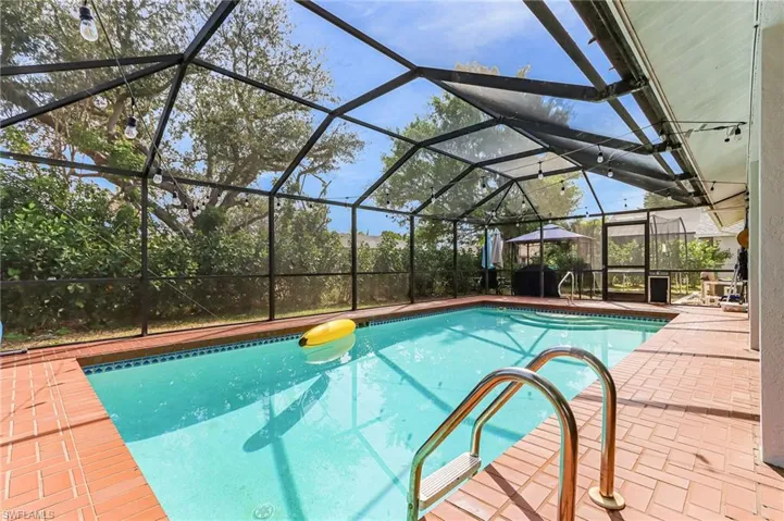 Swimming pool with a sunroom, glass enclosure, and a patio