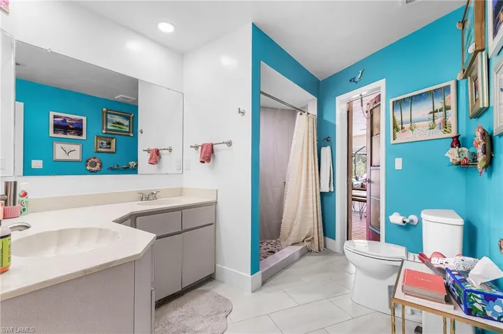 Full bath with double vanity and a shower stall