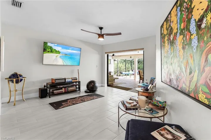 Living area featuring a ceiling fan and baseboards