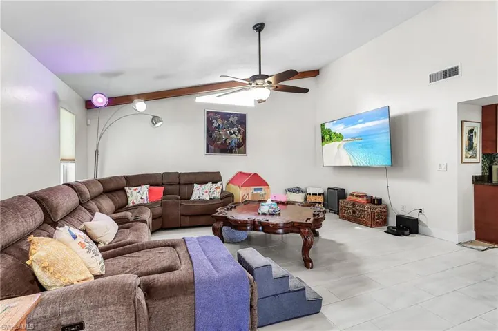 Living area featuring a ceiling fan and lofted ceiling