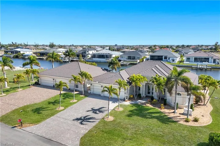 View of front of house featuring driveway, a residential view, an attached garage, a tile roof, and a water view
