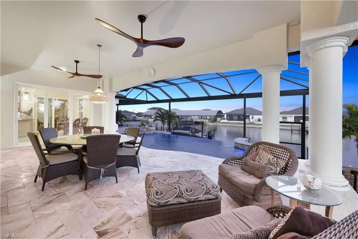 View of patio featuring a sunroom, an outdoor living / dining area, a ceiling fan, glass enclosure, and a residential view