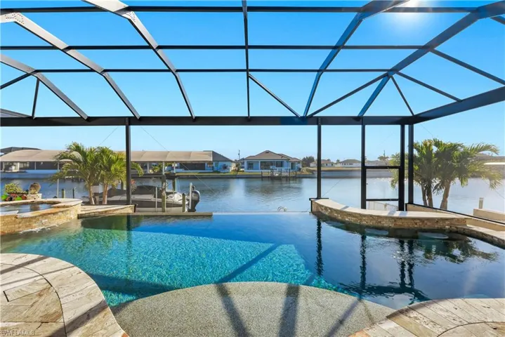 Combined pool / hot tub with a lanai, a sunroom, a boat dock, a residential view, and boat lift