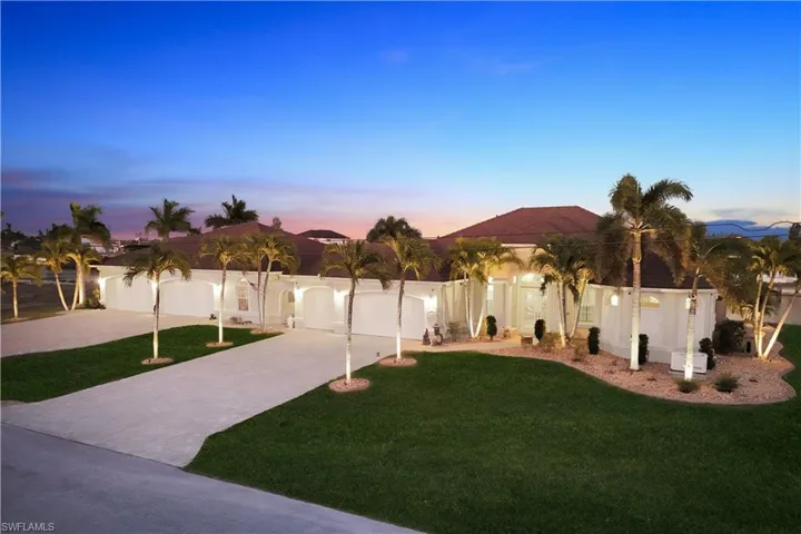 Yard at dusk featuring a lawn and driveway