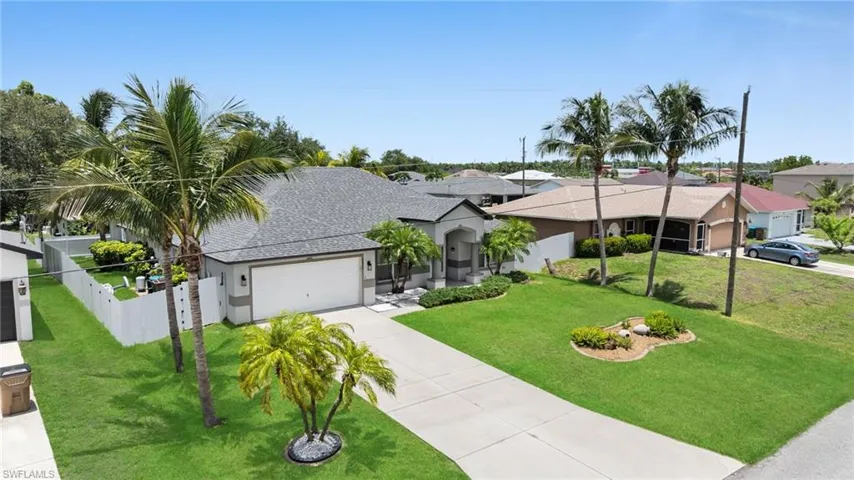 Single story home featuring driveweay, an attached garage, a residential view, and stucco siding