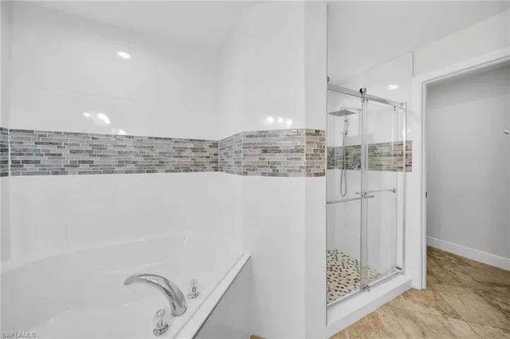 Bathroom with a stall shower and a garden tub