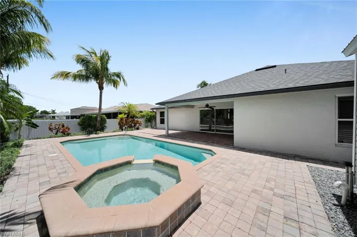 View of swimming pool featuring ceiling fan, a pool with connected hot tub, and a patio