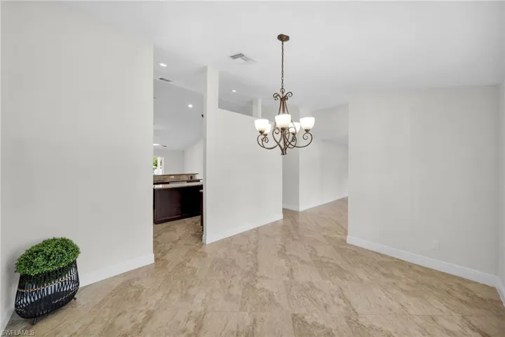 Unfurnished room with a c^handelier and ' recessed lighting
