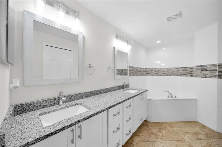 Bathroom with double vanity and a bath