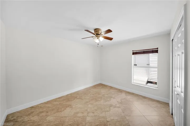 Unfurnished room with ceiling fan and baseboards